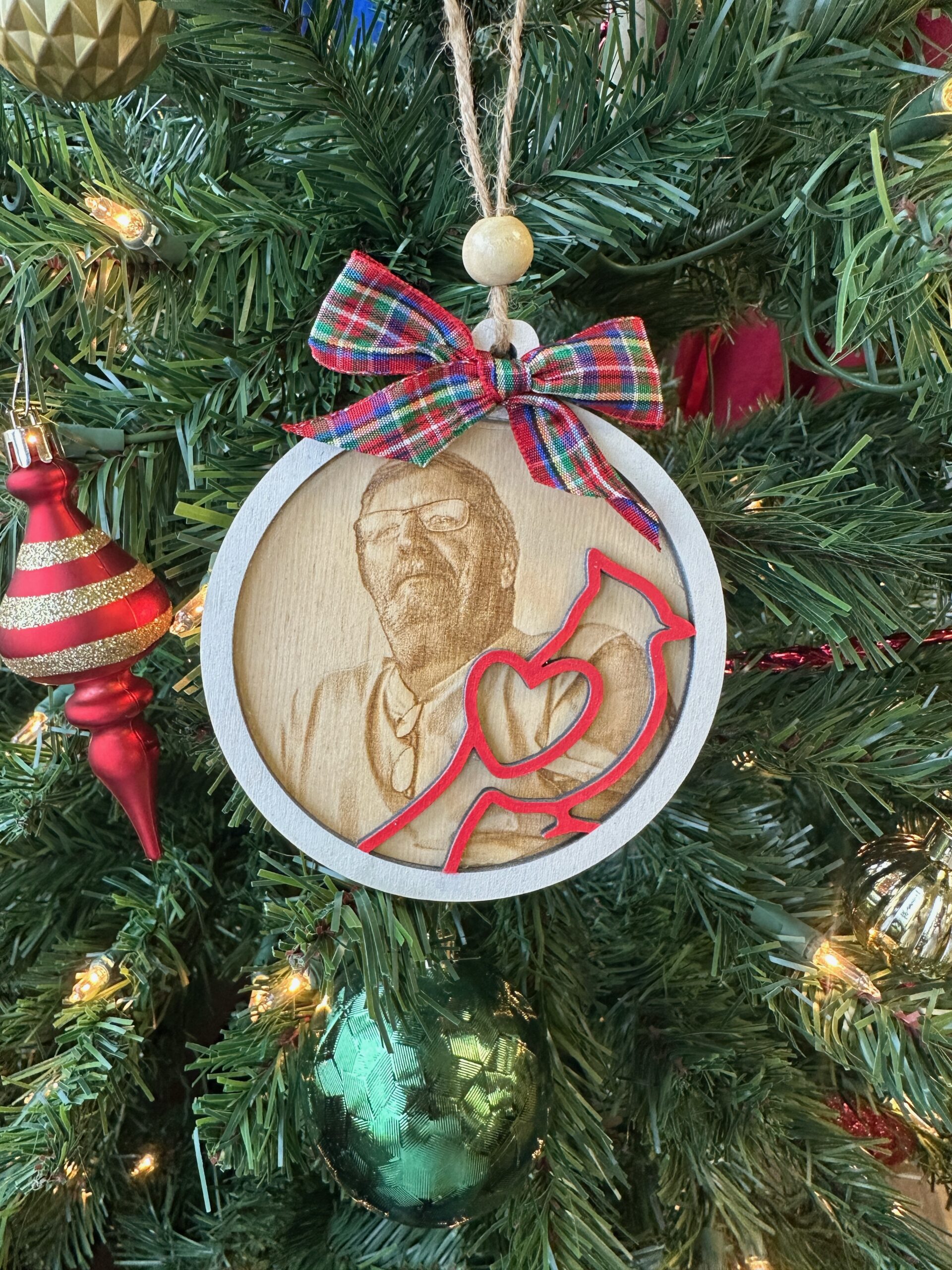 Personalized Cardinal Memorial Ornament – "Angels Are Near" Photo Tribute 2 ersonalized Cardinal Memorial Ornament hanging on a Christmas tree featuring a stained wood frame, laser engraved photo portrait, and red cardinal overlay