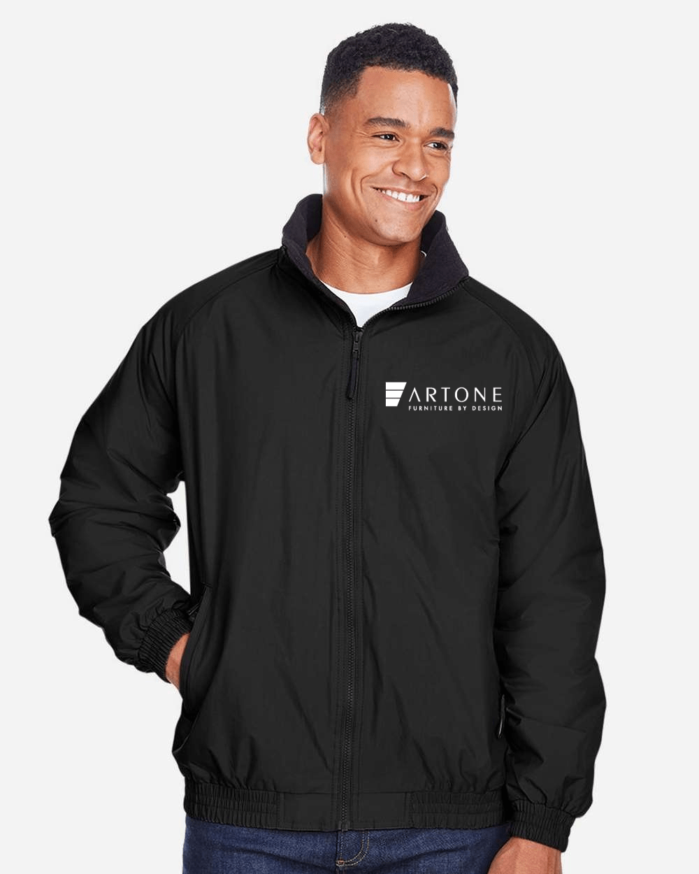 Harriton - Unisex Fleece Lined Nylon Jacket - M740 (Artone) 1 Male model smiling while wearing a custom black Harriton M740 fleece-lined jacket with the 'Artone Furniture by Design' logo on the left chest.