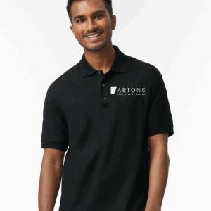Male model smiling while wearing a custom black Gildan 8800 polo shirt with the 'Artone Furniture by Design' logo on the left chest.