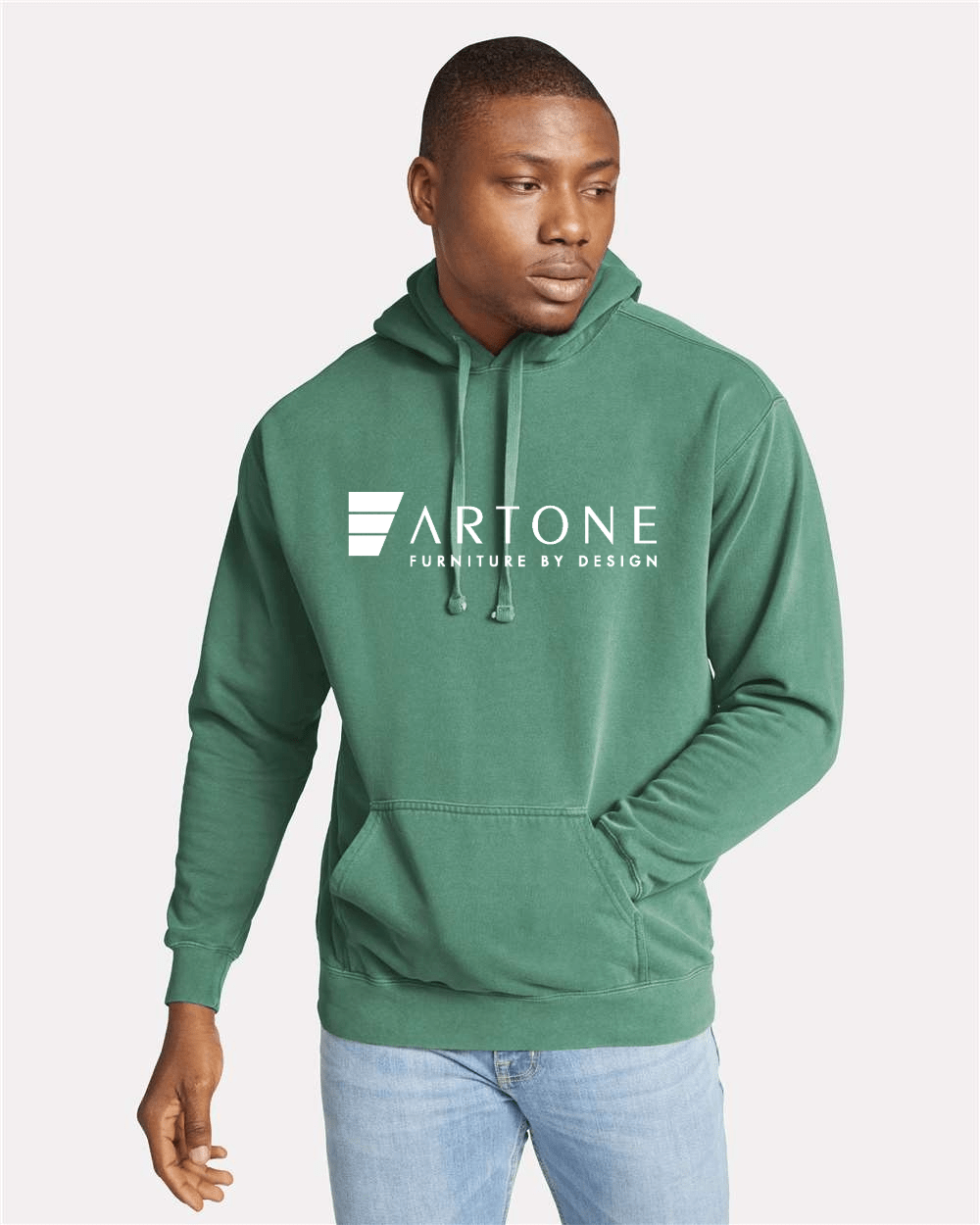 Comfort Colors - Unisex Garment-Dyed Hooded Sweatshirt - 1567 3 Male model wearing a custom light green Comfort Colors 1567 pullover hoodie with a large 'Artone Furniture by Design' logo on the center chest.