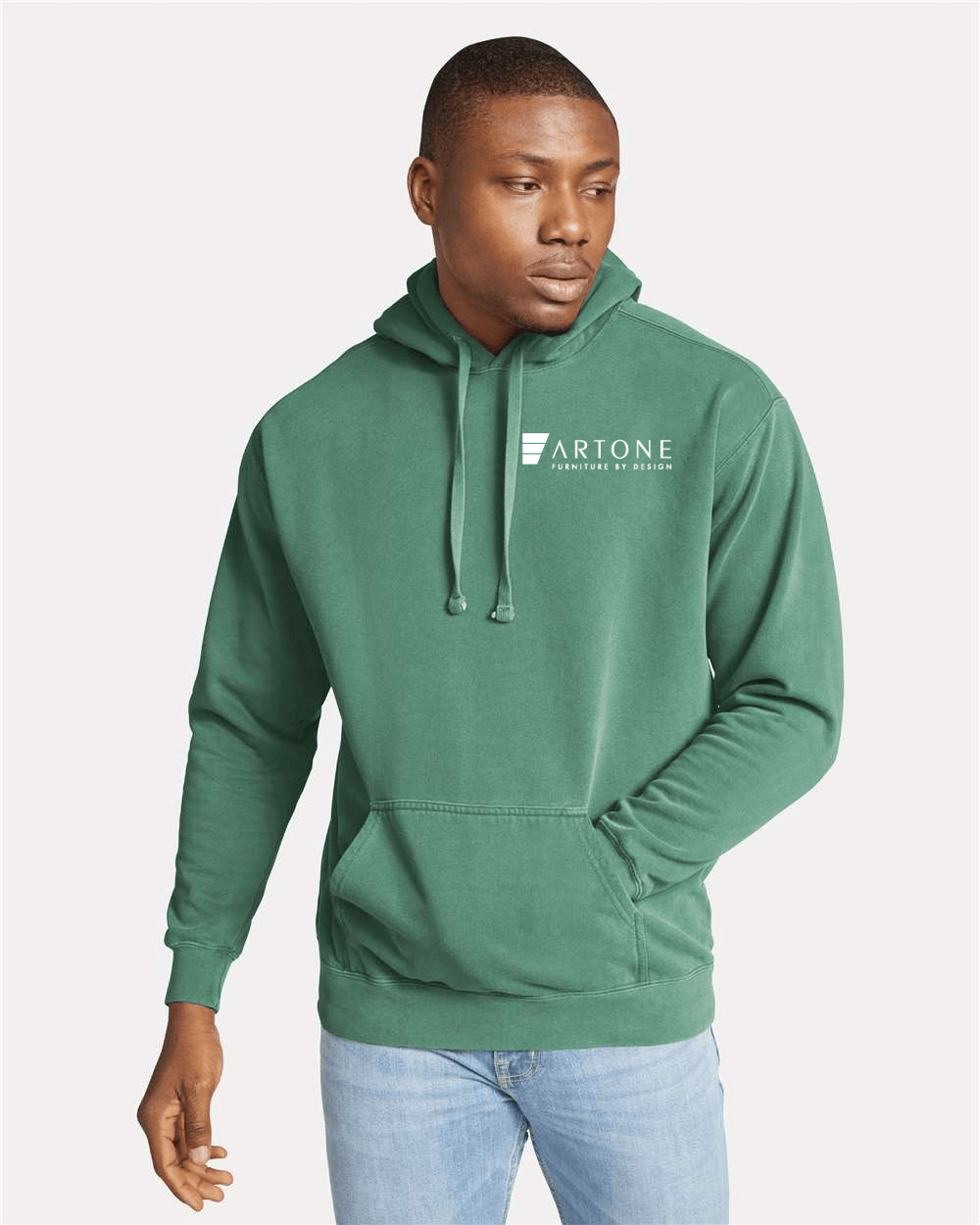 Comfort Colors - Unisex Garment-Dyed Hooded Sweatshirt - 1567 1 Male model wearing a custom light green Comfort Colors 1567 pullover hoodie with a large 'Artone Furniture by Design' logo on the left chest.
