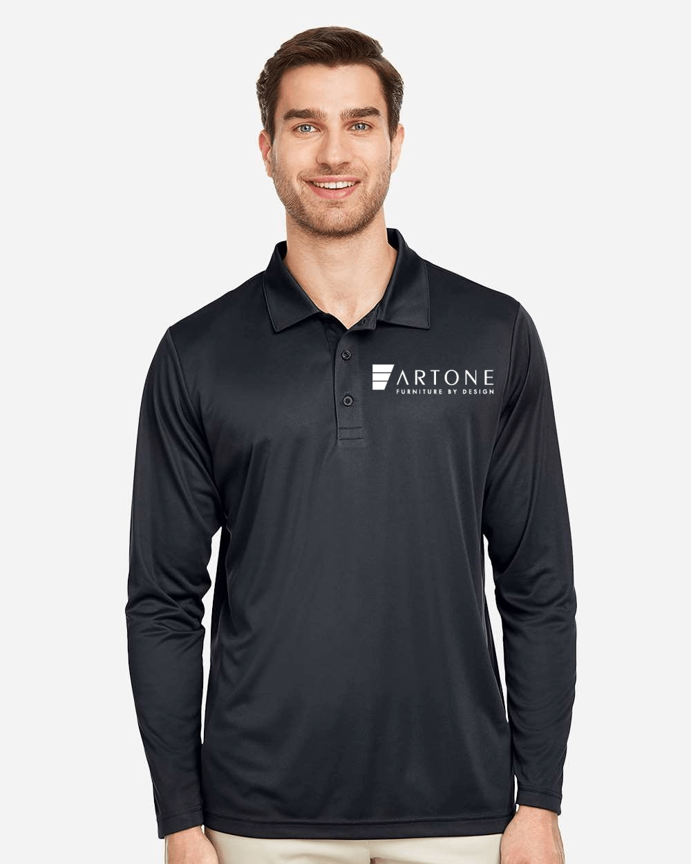 Team365 - Men's Zone Performance Long Sleeve Polo - TT51L (Artone) 1 Male model smiling while wearing a custom black Team 365 long-sleeve performance polo shirt with the 'Artone Furniture by Design' logo on the left chest.